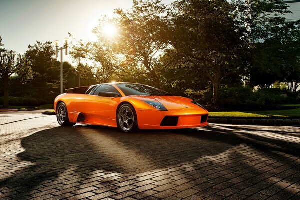 Voiture de sport orange sur le trottoir