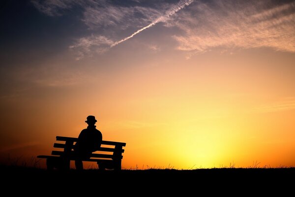 Silhouette of a man on a bench against the sunset