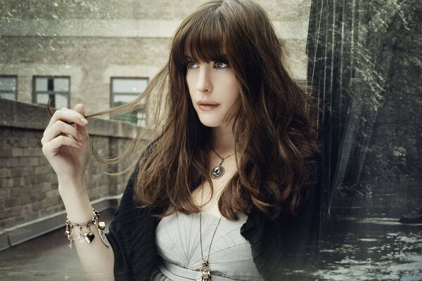 Portrait of a dark-haired girl on a stone bridge