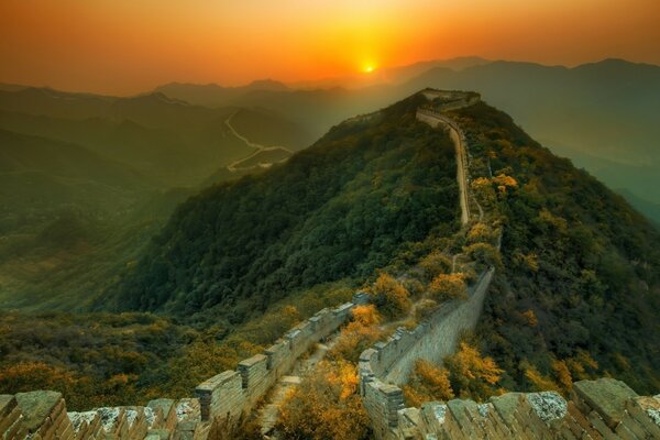 Ein Hügel mit einer chinesischen Mauer, der von der Morgendämmerung beleuchtet wird