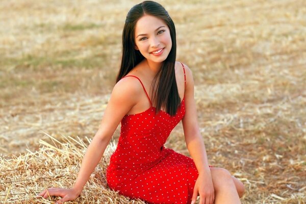 Beleza de cabelos negros em um vestido vermelho no campo