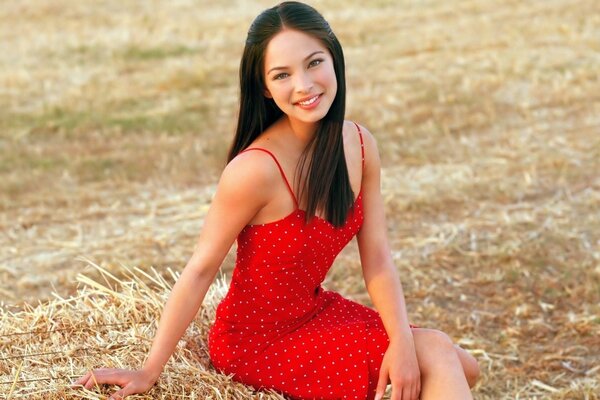 Черноволосая красавица в красном платье на поле