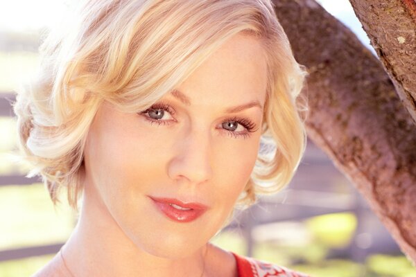 Portrait of a blonde actress near a tree