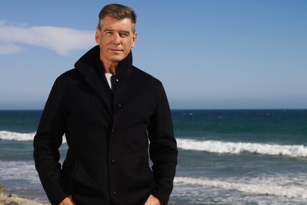 An adult man stands on the seashore