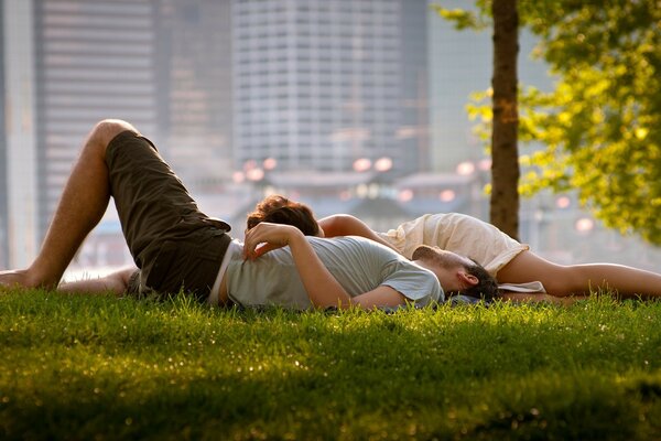 Couple d amoureux qui traînent sur l herbe dans le parc de la grande ville