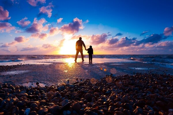 Vater und Sohn bewundern den Sonnenuntergang