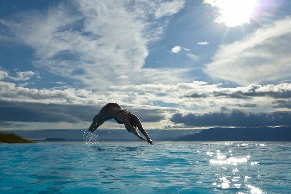 The girl dives in the water no worse than a dolphin