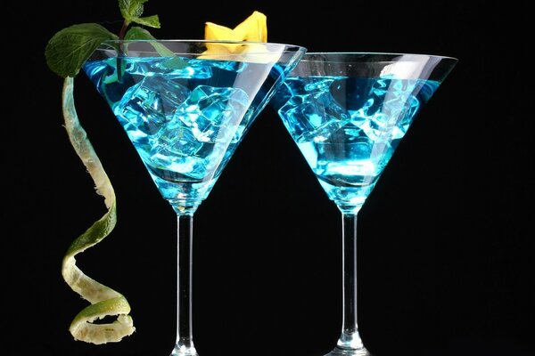 Two blue cocktails on a black background