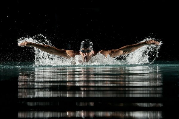 Breaststroke swimmer makes a wave with his hands