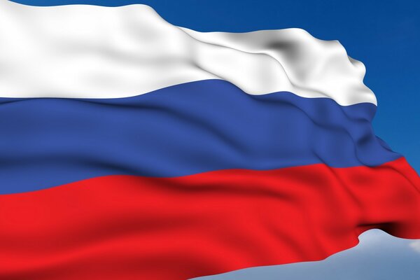 Развевающийся на ветру флаг России на фоне голубого неба