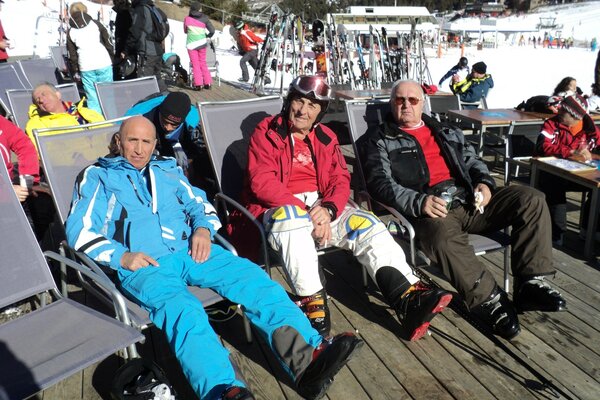 Touristen auf Liegestühlen im Skigebiet