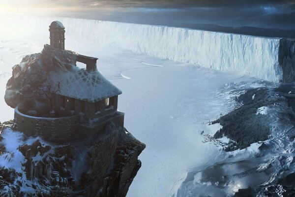 Uma casa coberta de neve em um penhasco rochoso