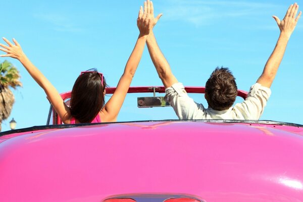 A couple in a pink convertible