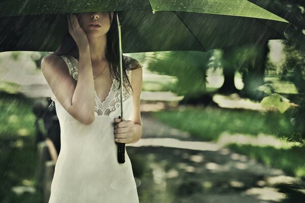 Fille dans une robe blanche sous un parapluie