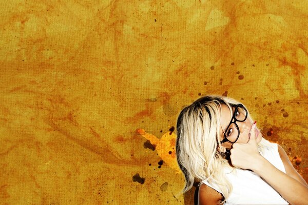 Blonde girl with glasses on a yellow background