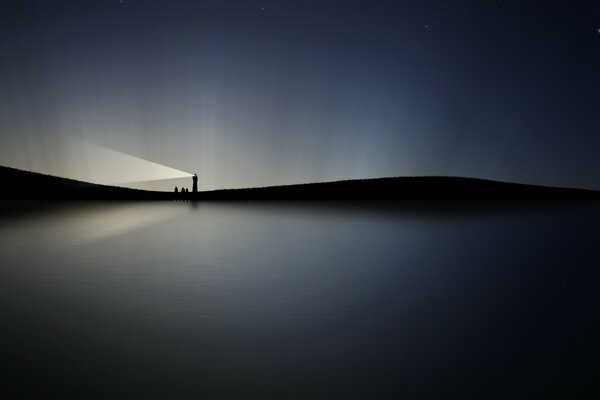 Evening twilight on the water and the light of the lighthouse