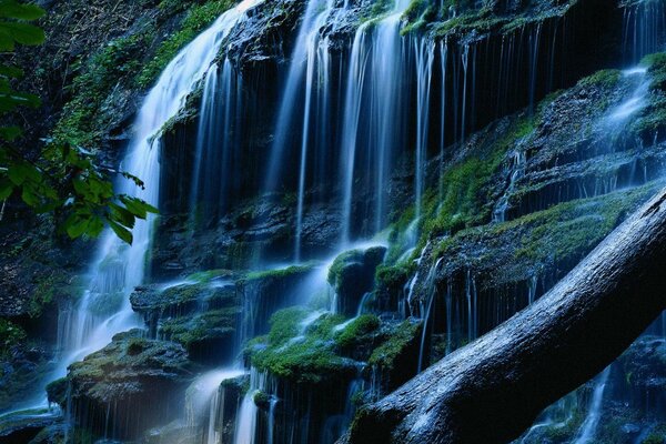 Malerischer Wasserfall unter moosigen Steinen