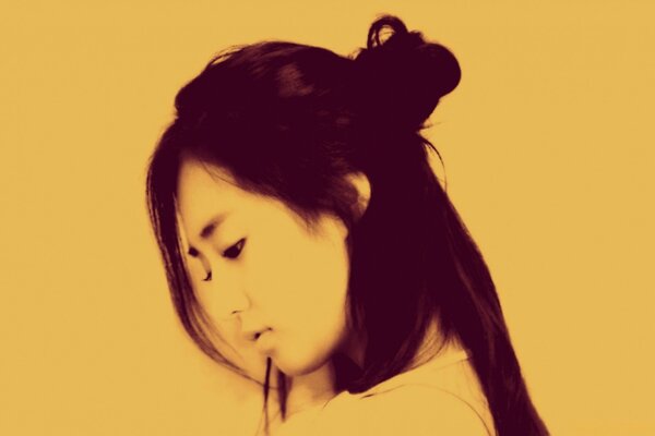 A girl in profile on a yellow background