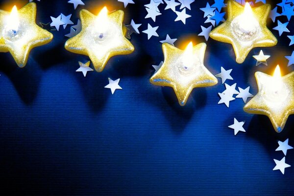 Mavi bir arka plan üzerinde altın yıldız mumları
