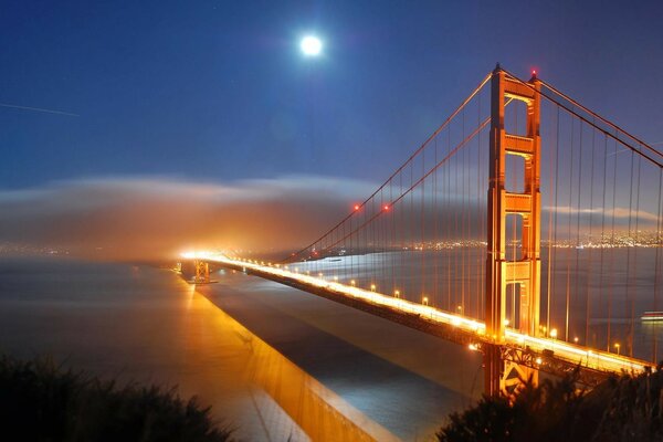 A bridge to the sunset. Reflection in the night river