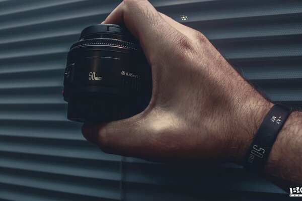 Camera lens in the photographer s hand