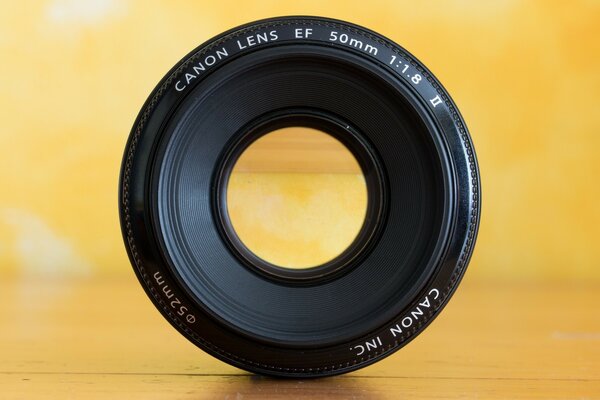 Canon camera lens on a yellow background