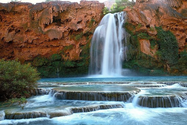 Majestic are the waterfalls flowing into the transparent river