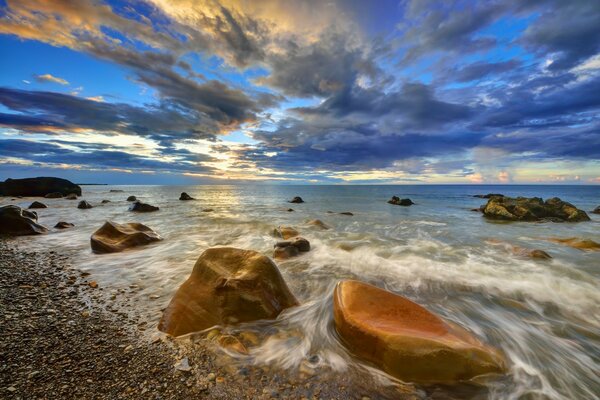 The sea surf breaks on the coastal rocks