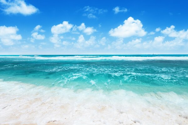 Clouds in the blue sky and turquoise waves