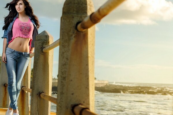 A menina ao pôr do sol está no cais