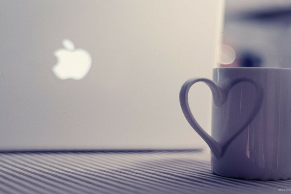 Taza al lado del MacBook