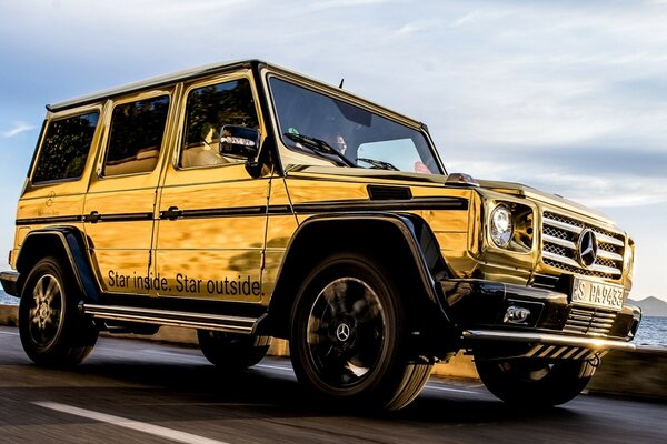 Um SUV amarelo viaja pela costa do mar