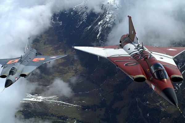 Aviones de combate en el aire volando sobre las montañas