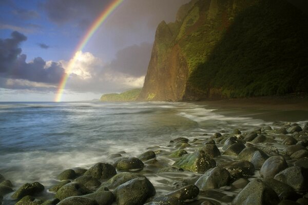 Arco iris en la orilla de las rocas