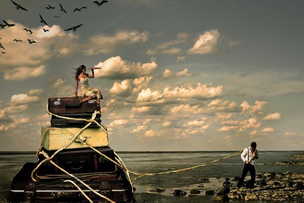 Un homme tire les valises d une belle fille sur la plage comme un Burlak