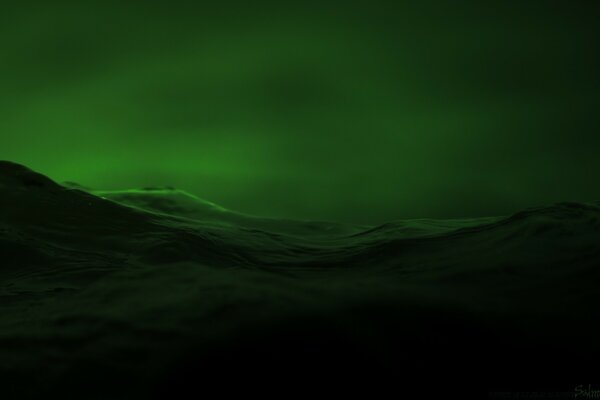 The sea waves in the green night