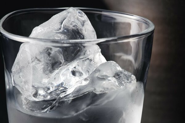 Cold transparent ice in a glass of water