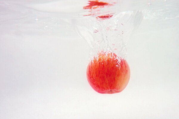 Красное яблоко в прзрачной холдной воде