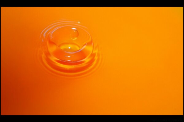 Orange drop of water in the juice