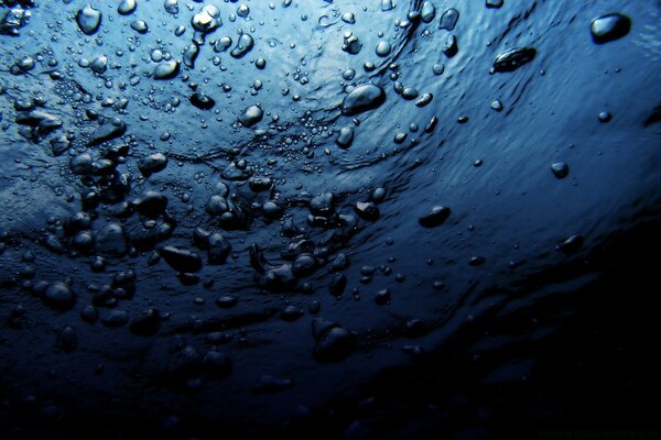 Macro disparo de agua con burbujas y gotas de color azul