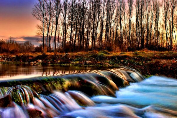 A picture of a stormy river in an autumn forest