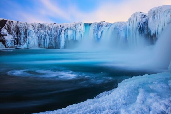 Frozen waterfalls around a mountain lake