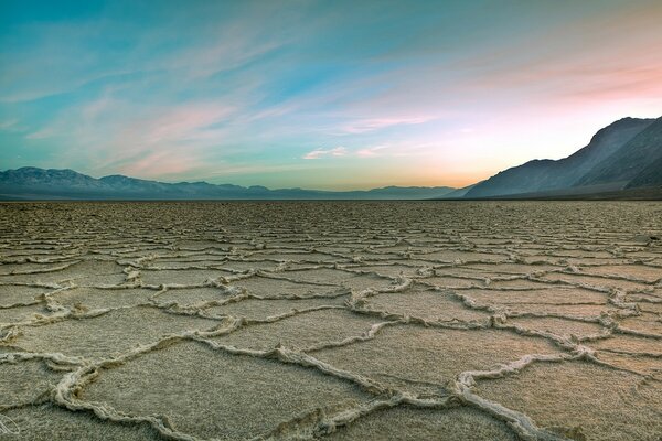 Terra a lungo senza acqua contro il cielo rosa