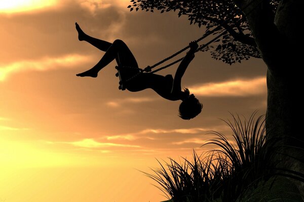 A girl swings on a swing against the sunset