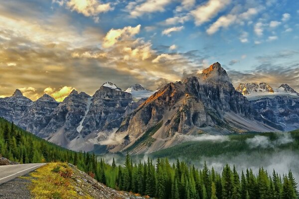 Altas montañas y bosque abajo al amanecer