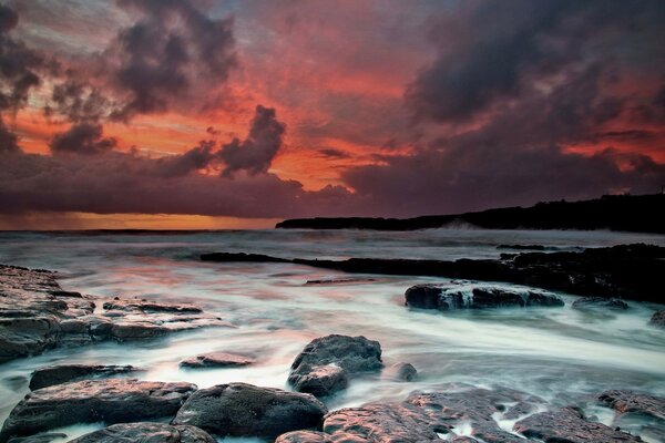 Atardecer en el agua con piedras