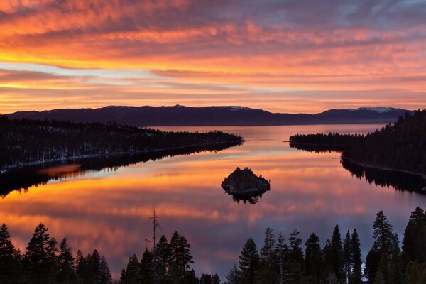 A beautiful sunset over a lake in the middle of the taiga, in the middle of which there is a small island