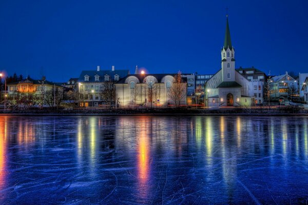 A frozen river with an ancient city at night on the shore