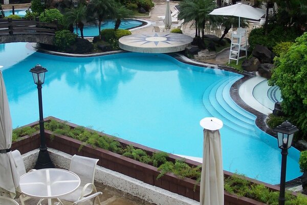 Blick vom Balkon auf den schicken Pool mit blauem Wasser