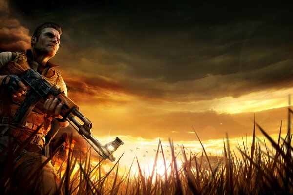 A guy with a machine gun on the background of sunset